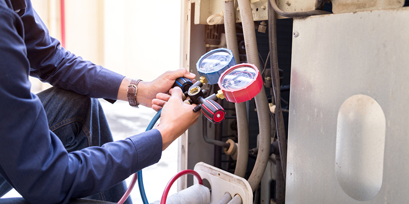 Technician checking refrigerant levels